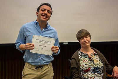 Student Dominic Limaldi holding the First Year Student Award, standing next to Professor Katie Roquemore.
