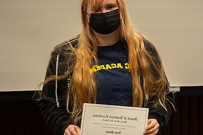 Student Lana Deane holding the Maria Forte Art Award.