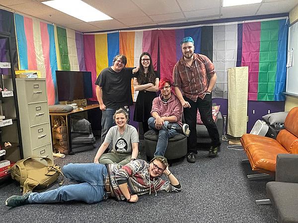 Six students posing for a photo in the Stonewall Center room.