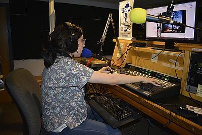 Image of student at sound board in radio station