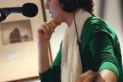 Photo of a student producing a radio program in the WLMC radio station studio.